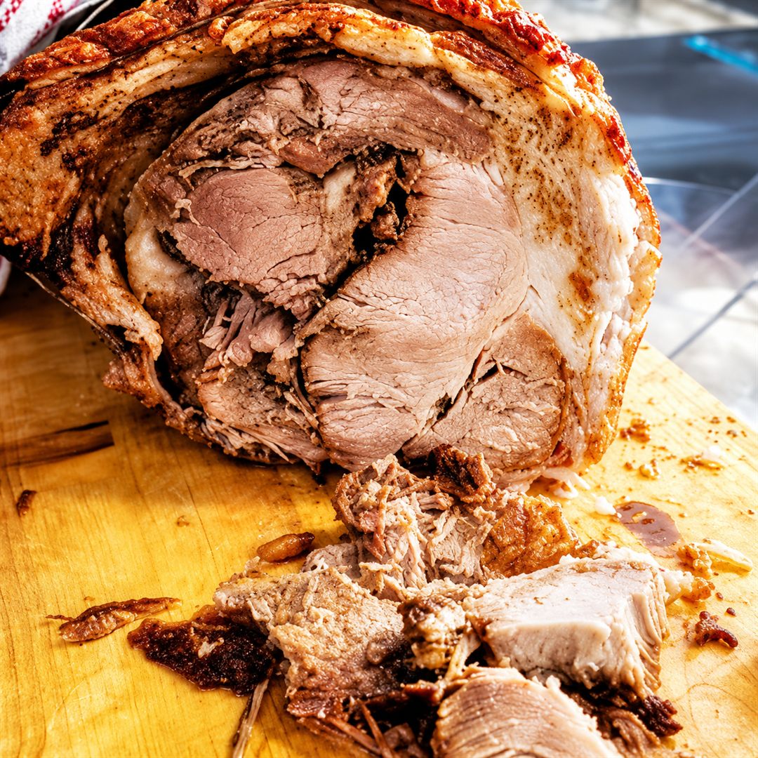 Porchetta toscana con crosta dorata e croccante, tagliata al coltello